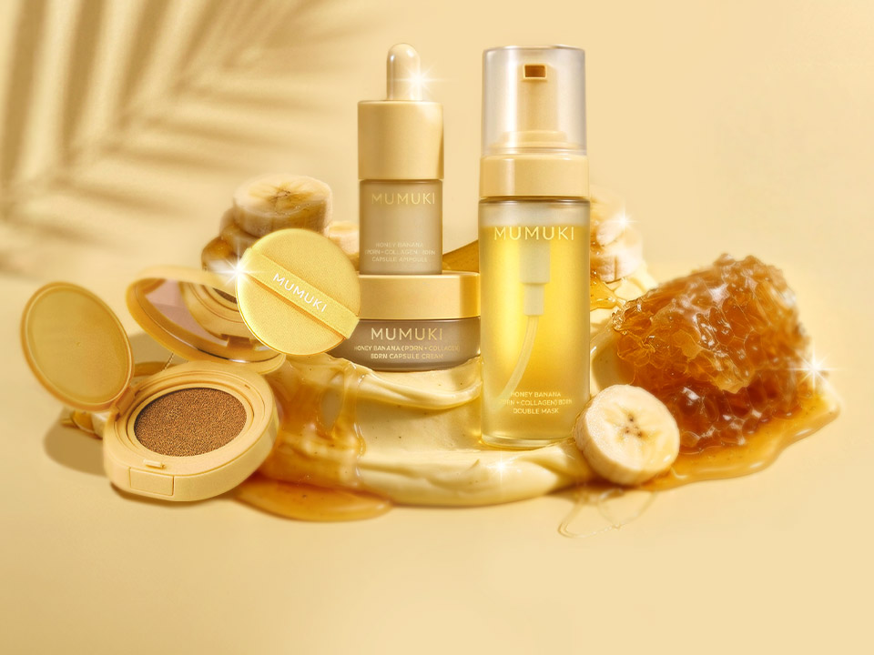 Golden-themed skincare collection displaying serums, creams, cushion compacts, and oils arranged with honey and fruit elements