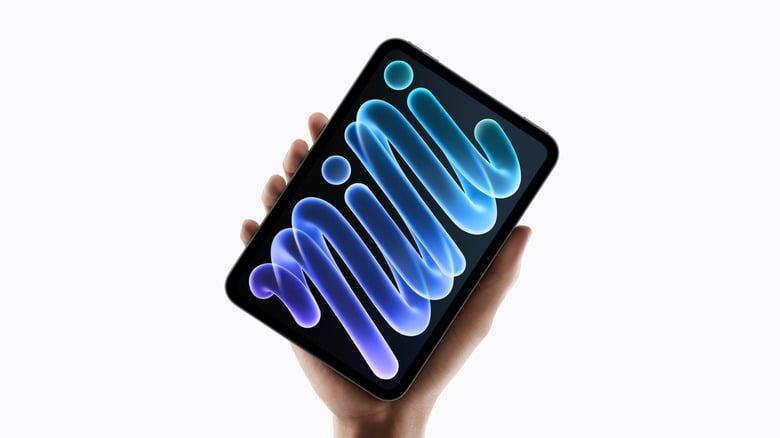Hand holding tablet with colorful glowing wave patterns on dark screen