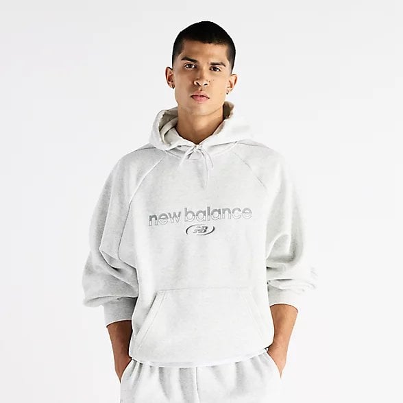 Person wearing white pullover hoodie with text logo and matching sweatpants