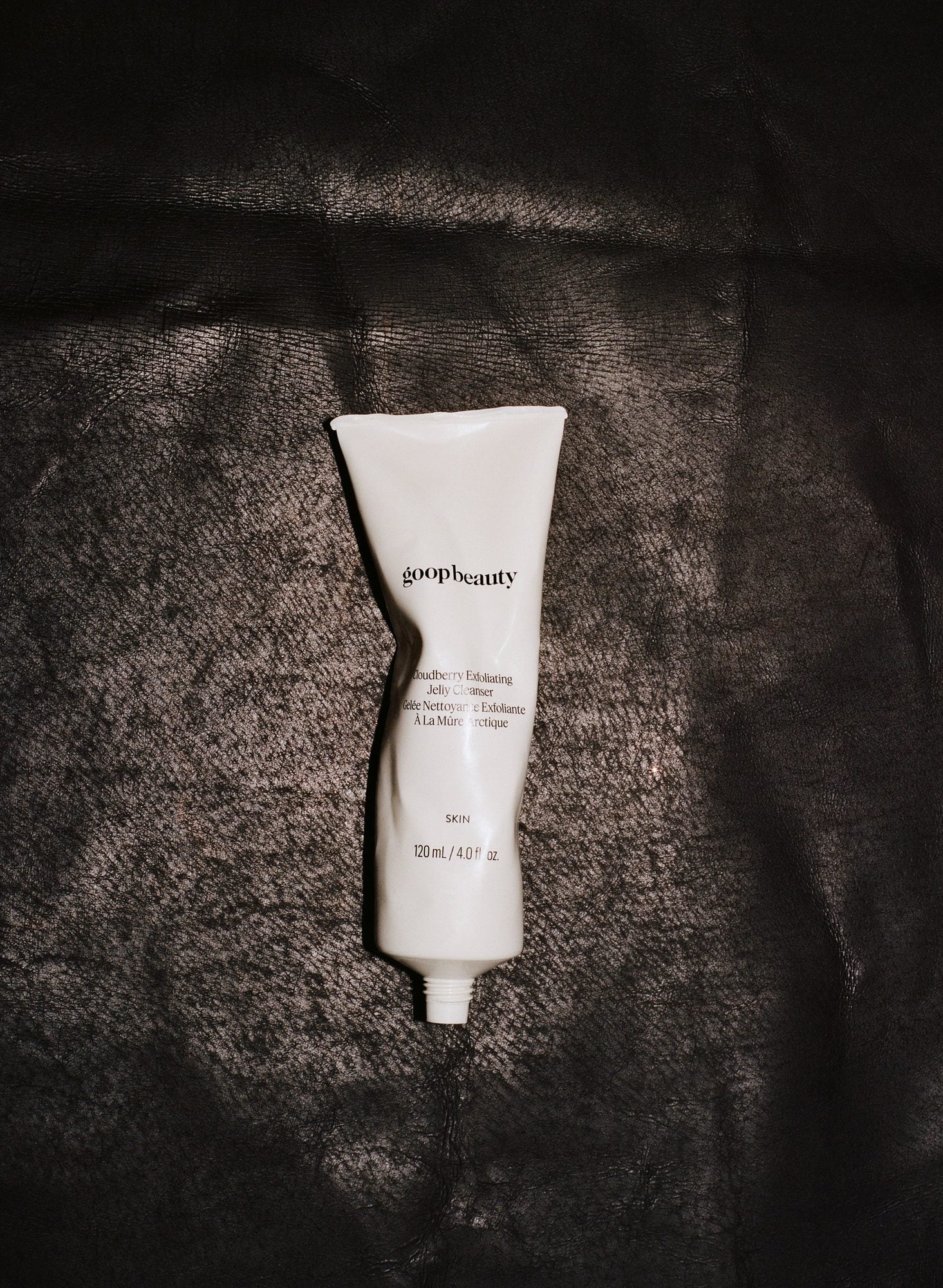 White tube of Cloudberry Exfoliating Jelly Cleanser on dark textured background